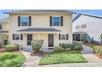 Charming two-story townhome featuring a well-maintained lawn and inviting front porch at 1220 Villa Ln # 135, Apopka, FL 32712