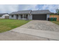 Charming single-story home featuring a two car garage, fresh landscaping, and a driveway with a basketball hoop at 1659 Nantucket St, Deltona, FL 32725