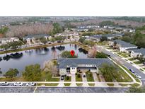 Aerial view showcasing the townhouse community with a central pond feature at 5409 Caramella Dr, Orlando, FL 32829