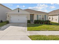 Charming single-story home with a well-maintained lawn, two-car garage, and neutral color scheme at 5654 Winona Dr, St Cloud, FL 34771