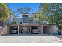 Townhouse exterior featuring covered parking and lush greenery at 108 Crown Oaks Way # 102, Longwood, FL 32779