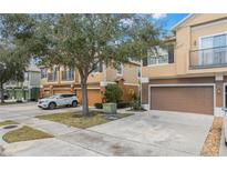 Inviting townhome exterior featuring a two-car garage and a well-maintained lawn at 15319 Oak Apple Ct, Winter Garden, FL 34787