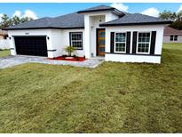 Charming single Gathering home featuring a front yard, an attached garage and modern architectural design at 15657 Sw 37Th Cir, Ocala, FL 34473