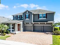 Stunning two-story home with a three-car garage, brick-paved driveway, and well-manicured landscaping at 16033 Citrus Knoll Dr, Winter Garden, FL 34787