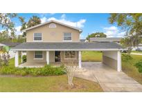 Charming two-story home featuring a covered porch and carport, set in a lush green lawn at 1604 Roosevelt Ave, Orlando, FL 32804