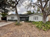 Charming one-story home featuring new paint, dark shutters, and mature landscaping at 1712 Lake Lorine Dr, Orlando, FL 32808