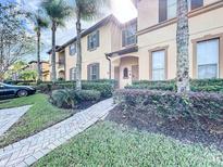 Inviting two-story townhome with lush landscaping and charming walkway at 569 La Mirage St, Davenport, FL 33897