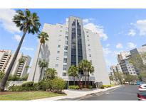 Modern high-rise building with elegant landscaping and tall palm trees, providing a luxurious and inviting curb appeal at 6165 Carrier Dr # 2306, Orlando, FL 32819