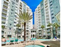 Resort-style pool area with palm trees and luxurious lounge chairs, perfect for relaxation and entertainment at 7395 Universal Blvd # 1005, Orlando, FL 32819