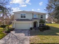 Charming two-story home with a brick driveway, well-manicured lawn, and attached two-car garage at 9026 Paolos Pl, Kissimmee, FL 34747