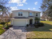 Charming two-story home featuring a paved driveway, tile roof, and a well-manicured lawn at 9026 Paolos Pl, Kissimmee, FL 34747