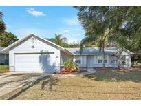 Charming single-story home with a well-manicured lawn and a two-car attached garage at 1995 Brewster Dr, Deltona, FL 32738