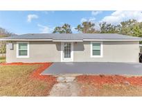 Charming single-story home featuring a metal roof, tidy landscaping, and a welcoming front entrance at 2121 Woodland Dr, Apopka, FL 32703