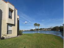 Exterior shot featuring a large body of water surrounded by well-manicured grass and two palm trees at 536 Orange Dr # 16, Altamonte Springs, FL 32701