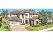 Elegant two-story home featuring a tile roof, stone accents, a three-car garage and a charming balcony at 5774 Fulham Pl, Sanford, FL 32771