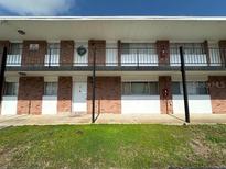 A cozy condo complex features a brick facade, complemented by verdant landscaping and an inviting entrance at 801 W Lancaster Rd # 92, Orlando, FL 32809