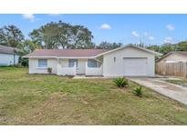 Charming single-story home featuring a well-maintained lawn, attached garage, and freshly painted exterior at 807 Vercelli St, Deltona, FL 32725