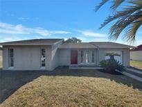 Charming single-story home featuring a well-manicured lawn and mature palm tree at 145 Zacalo Way, Kissimmee, FL 34743