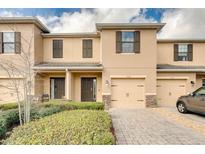 Inviting townhouse with brick-paved driveway and manicured landscaping at 1558 Downy Birch Ln, Longwood, FL 32750