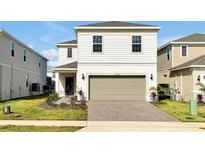 Charming two-story home featuring a neutral color palette, attached garage, and a well-manicured front yard at 16207 Trinidad Way, Clermont, FL 34714