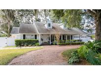 Charming single-Gathering home featuring a brick driveway and a beautifully landscaped front yard with mature trees at 181 N Phelps Ave, Winter Park, FL 32789