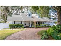 Charming home featuring a circular brick driveway, manicured landscaping, and a bright white exterior at 181 N Phelps Ave, Winter Park, FL 32789