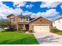 Charming two-story home with a well-maintained lawn, inviting curb appeal, and an attached two-car garage at 1920 Partin Terrace Rd, Kissimmee, FL 34744