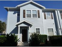 Charming two-story townhouse featuring light blue siding, brown shutters, and well-maintained landscaping at 2903 Edenshire Way # 108, Kissimmee, FL 34746