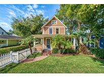 Charming two-story home with a well-manicured lawn, white picket fence and beautiful landscaping at 122 N Hyer Ave, Orlando, FL 32801