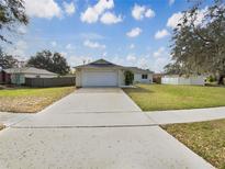 Charming single-story home featuring a well-maintained lawn and an attached two-car garage at 13842 Belvin Ct, Orlando, FL 32826