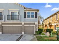 Two-story townhome featuring individual garages, a balcony and muted blue and gray color scheme at 1710 San Jacinto Cir # 1710, Sanford, FL 32771