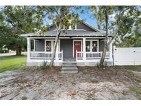 Charming gray home with a cozy front porch and red front door at 202 Division, Deland, FL 32720