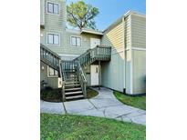 Inviting condo exterior with wooden stairs leading to the upper unit entrance at 282 Scottsdale Sq # 282, Winter Park, FL 32792