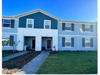 Charming townhome with a blue exterior, well-manicured lawn, and inviting walkway at 3926 Lana Ave, Davenport, FL 33897