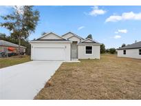 Charming single-story home with a two-car garage and neutral-colored stucco exterior and well-maintained lawn at 855 S Hancock Dr, Deltona, FL 32725