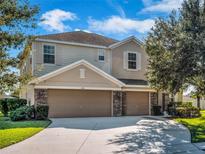 Two-story home with a three-car garage, stone accents, and well-maintained landscaping at 1144 Legg Dr, Apopka, FL 32712