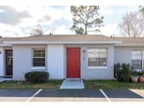 Charming home featuring a vibrant red front door and meticulously maintained landscaping at 124 Lake Villa Way, Kissimmee, FL 34743