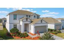 Well-kept two-story home with a brown roof and manicured landscaping in the front yard at 1260 Tupelo Trl, Haines City, FL 33844