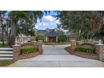 Beautiful estate home featuring brick entrance with landscaped garden, water feature, and manicured grounds under a blue sky at 1501 Lake Markham Rd, Sanford, FL 32771