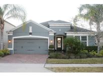 Charming single-Gathering home featuring a well-maintained lawn, a brick driveway, and a two-car garage at 1738 Farmstead Ln, Oviedo, FL 32765