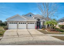 Charming one-story home with a three-car garage, stone accents, and well-manicured landscaping at 2512 Stoneworth Ct, Orlando, FL 32825