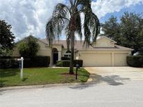 Charming one-story home with a three-car garage, manicured lawn, and mature landscaping at 305 Grand Reserve Dr, Davenport, FL 33837
