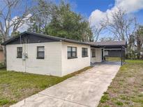 Charming single-story home with a white brick exterior and black trim, a covered carport, and a concrete driveway at 425 Walnut St, Daytona Beach, FL 32114