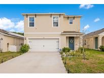 Two-story home with manicured lawn, a two-car garage, and welcoming blue front door at 574 Lady Grace Pl, Deland, FL 32724