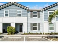 Charming two-story townhome with light blue siding and neat landscaping offers a welcoming curb appeal at 7509 Oak Spring Ln, Davenport, FL 33837