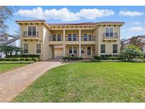 Stunning two-story home with a red tile roof, a manicured lawn, and a brick driveway at 8424 Lake Burden Cir, Windermere, FL 34786