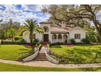 Stunning white home boasts a red tile roof, lush landscaping, and a welcoming front entrance at 900 S Lake Adair Blvd, Orlando, FL 32804