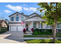 Charming two-story home with a two-car garage, covered entry, manicured lawn, and an American flag at 9192 Bradleigh Dr, Winter Garden, FL 34787