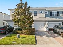 Charming townhome featuring a two-car garage, manicured lawn, and inviting curb appeal at 10731 Savannah Wood Dr # 209, Orlando, FL 32832