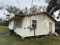 Exterior view of a one-story home with a white stucco finish and a weathered roof at 2219 W Pine St, Orlando, FL 32805